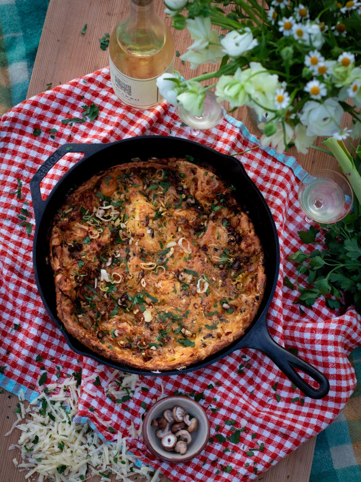 picnic with food in a pan and flowers and wine
