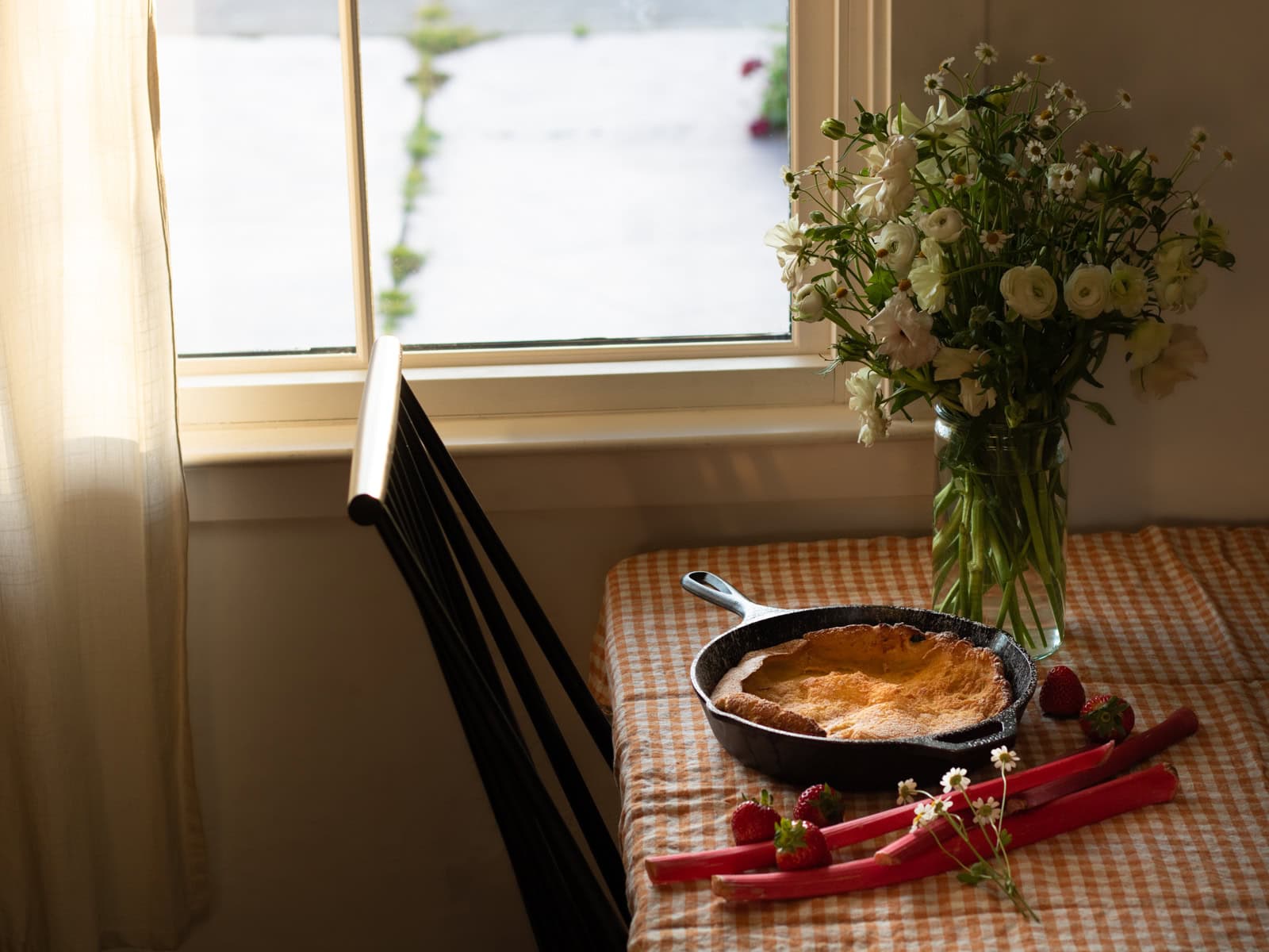 dutch baby in a pan on a table with flowers